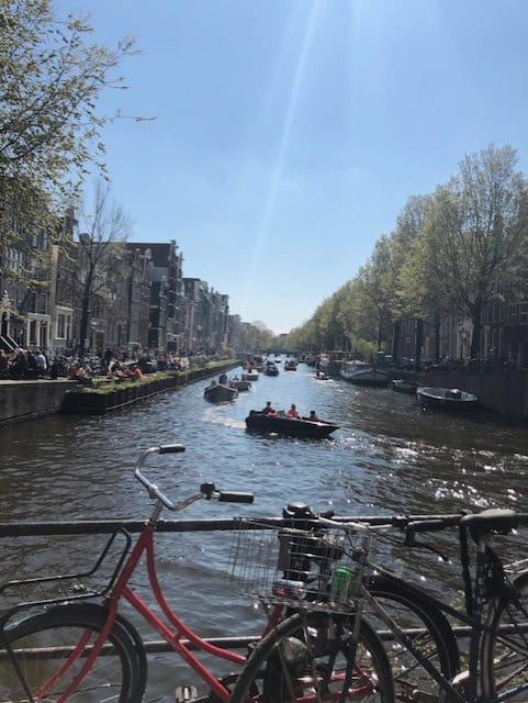 Bike parked in front of river and boats