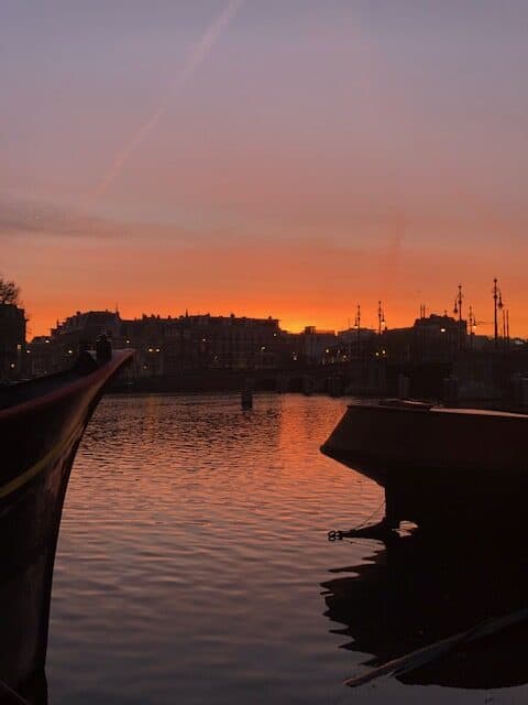 Sunset over the Amstel River in Amsterdam with the sunset reflecting in the water