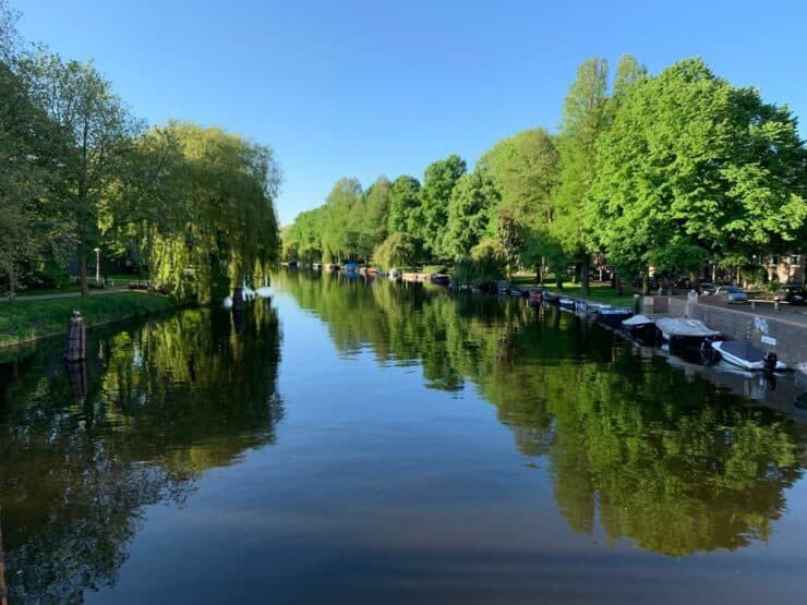 Green Trees line a blue canal