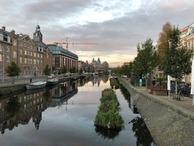 View of a canal with old buildings on either side and the Rijksmuseum in the background