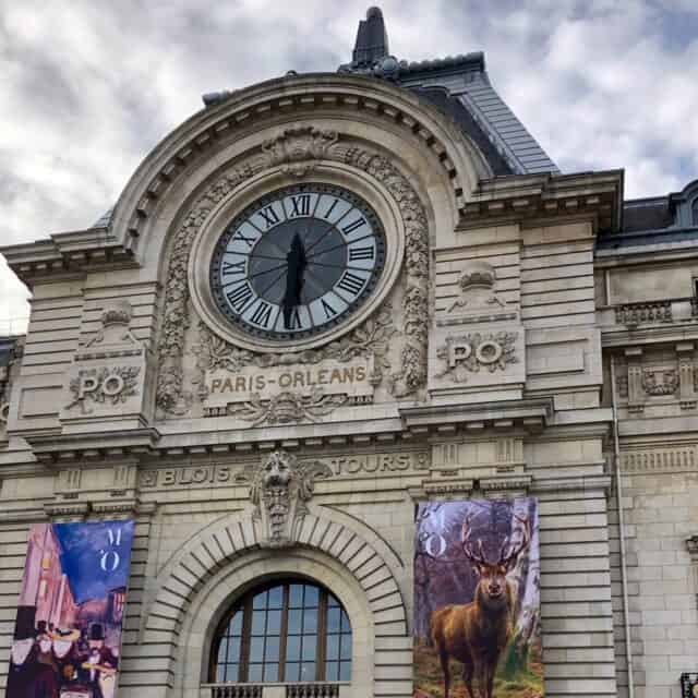 Musée d'Orsay - Old Building with large clock and banners on either side of the door