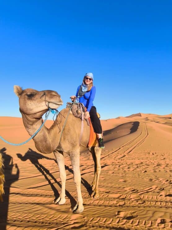 woman sitting on a dromedary in the desert in Morocco