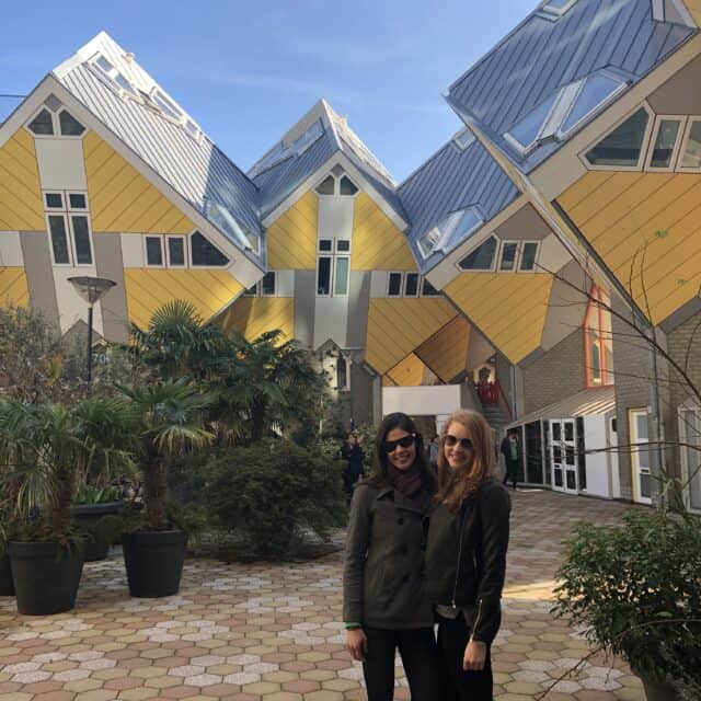 Two smiling women in front of the famous cube houses, an essential stop for One day in Rotterdam